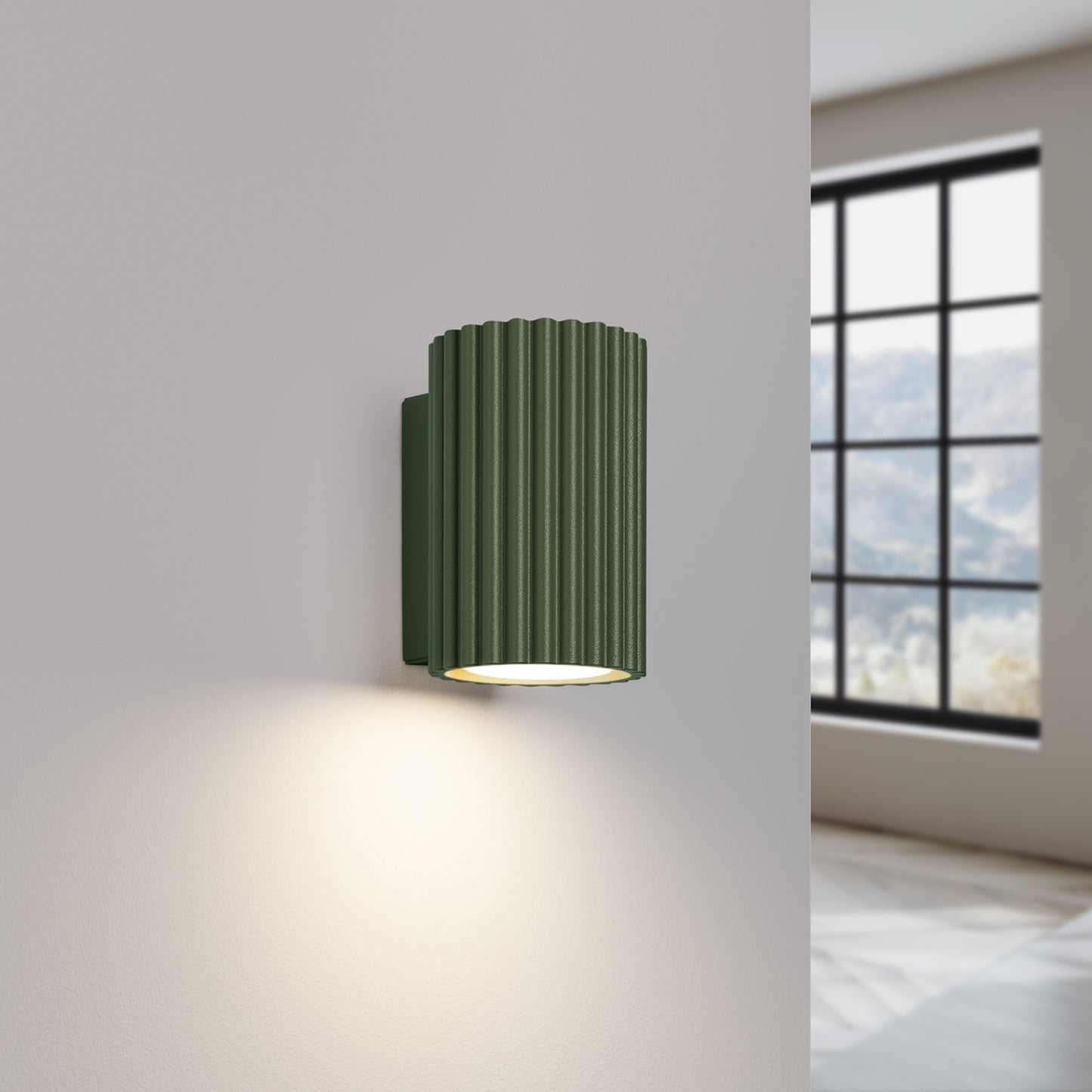 Olive Green Mini Ribbed Cylinder Wall Light switched on in modern UK home interior, warm LED glow