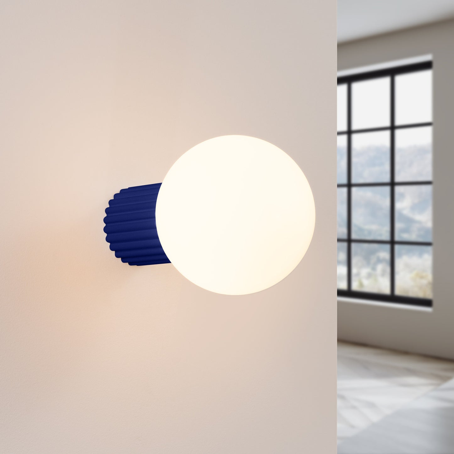 Ultramarine Opal Glass Globe Wall Light IP44 switched on in modern UK home interior, warm LED glow