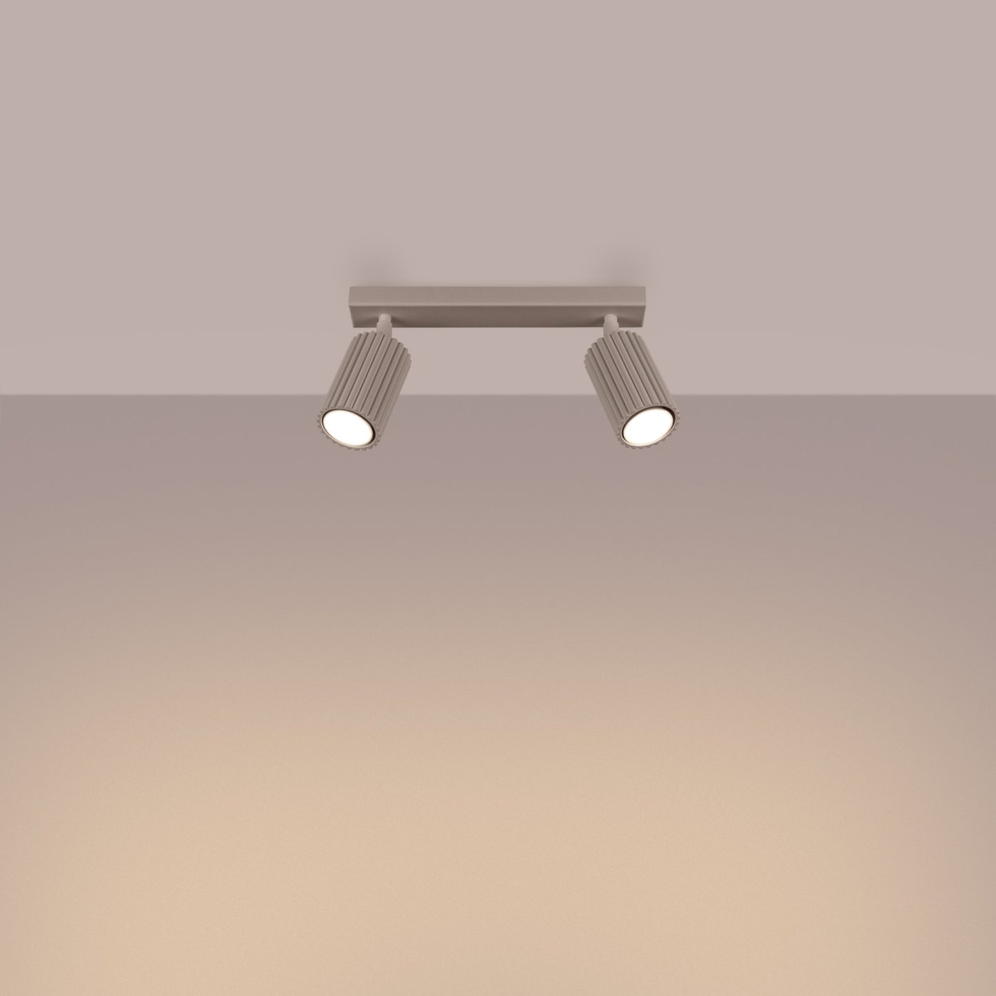 Taupe Twin Ribbed Surface Spotlight switched on in modern UK home interior, warm LED glow
