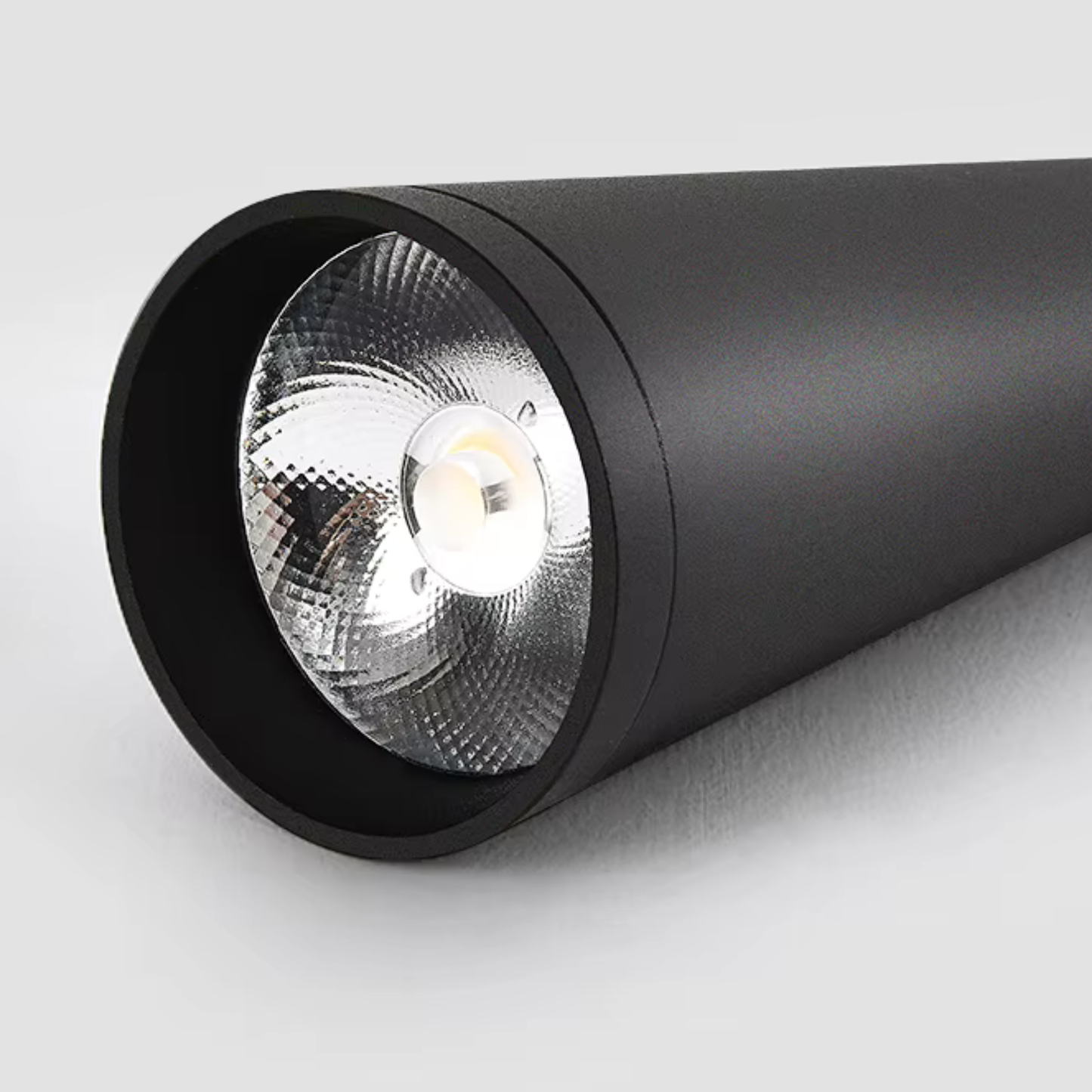 Black cylindrical spotlight on a light gray background