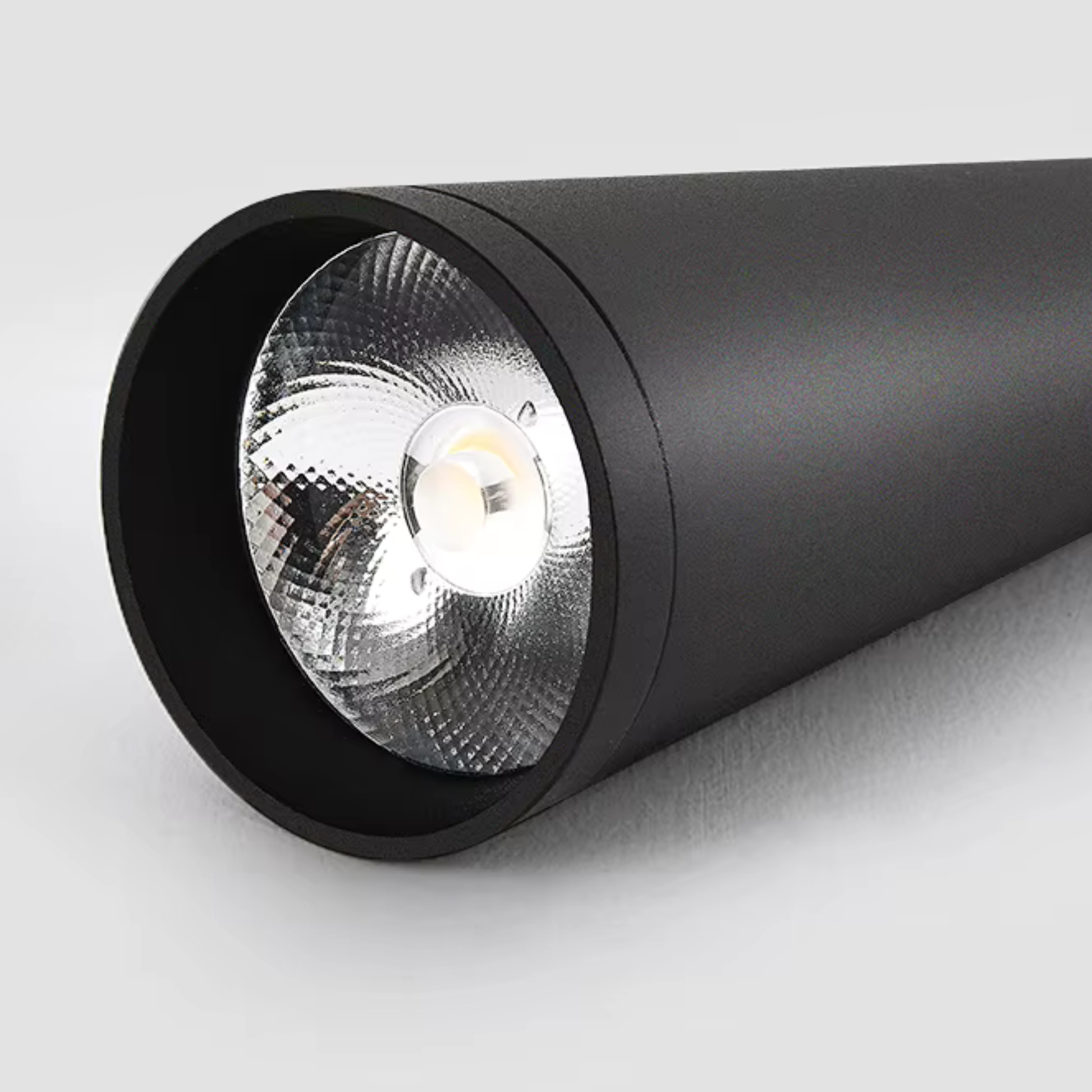 Black cylindrical spotlight on a light gray background
