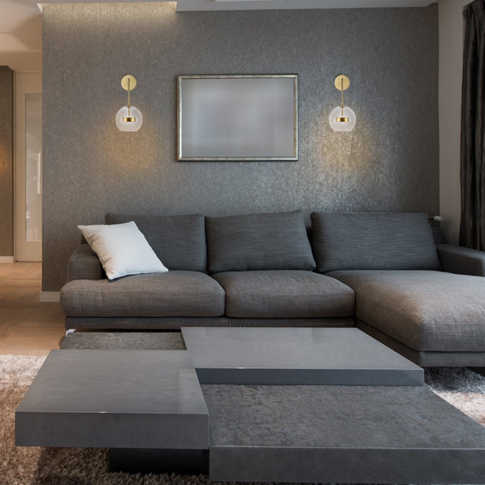 Gold Clear Globe L Arm Wall Light installed in modern UK home interior with warm LED glow, contemporary lighting design
